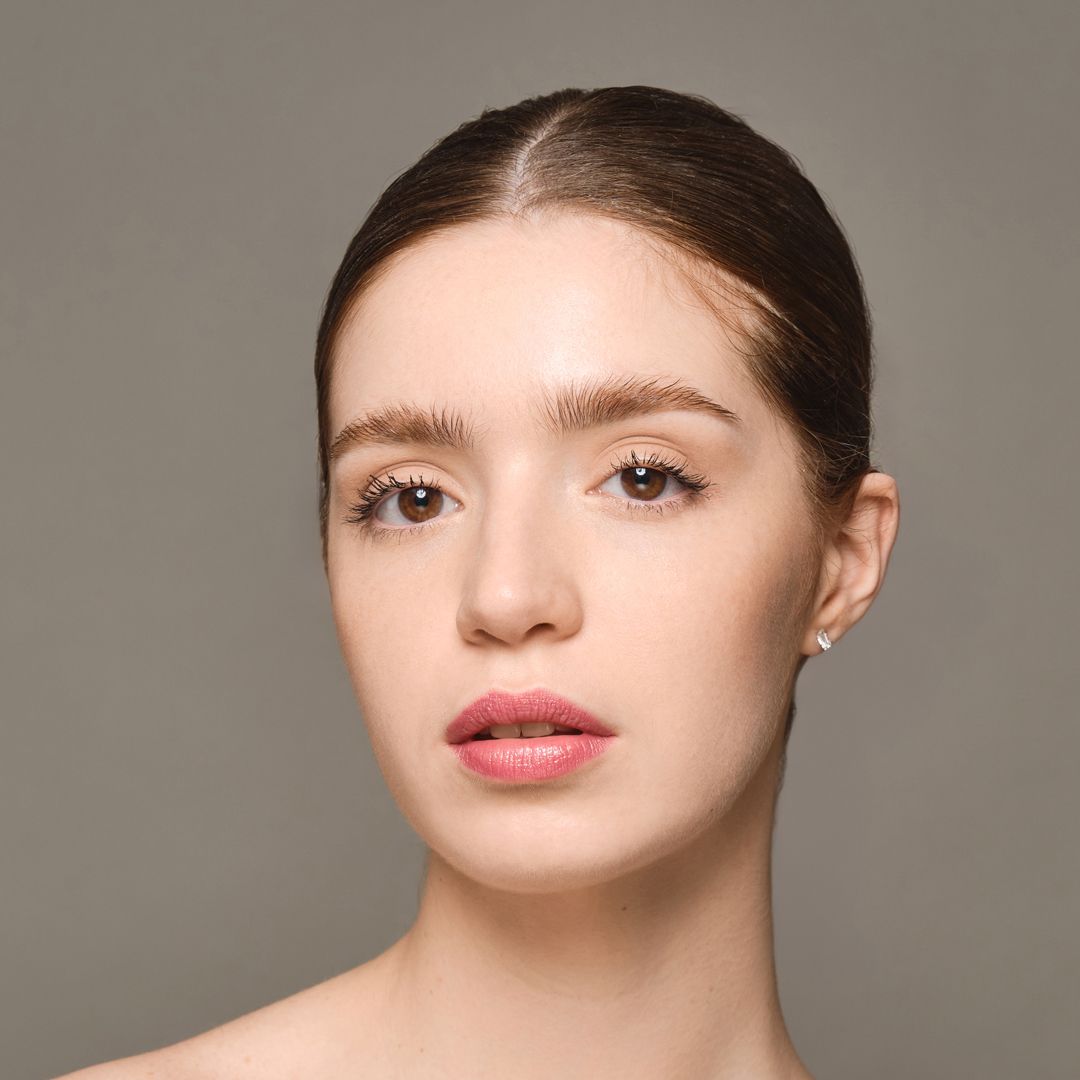 Baume lèvres Moniamori Supreme Lip Treatment Fraise posé sur une surface élégante, reflétant sa texture fondante et son éclat naturel.