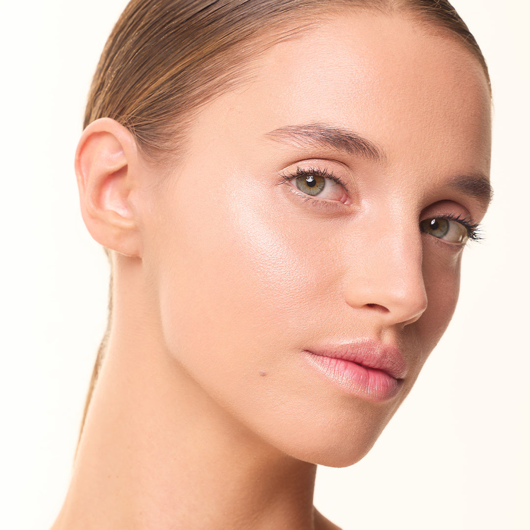 Mannequin portant le highlighter MoniAmori Light & Go teinte Champagne, lumière douce sur les pommettes et l’arête du nez, effet glowy naturel et lumineux.