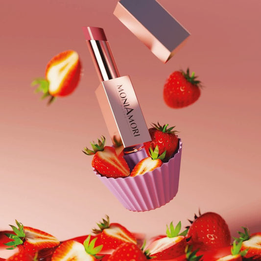 Soin lèvres Supreme Lip Treatment Fraise de Moniamori entouré de fraises fraîches, illustrant sa douceur et sa gourmandise.