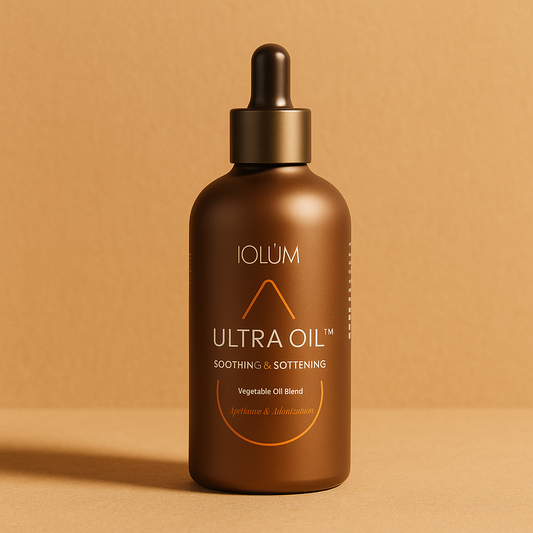 Flacon IOLÙM Ultra Oil™ posé sur un fond beige naturel, mettant en valeur une huile végétale apaisante et adoucissante pour peaux sensibles